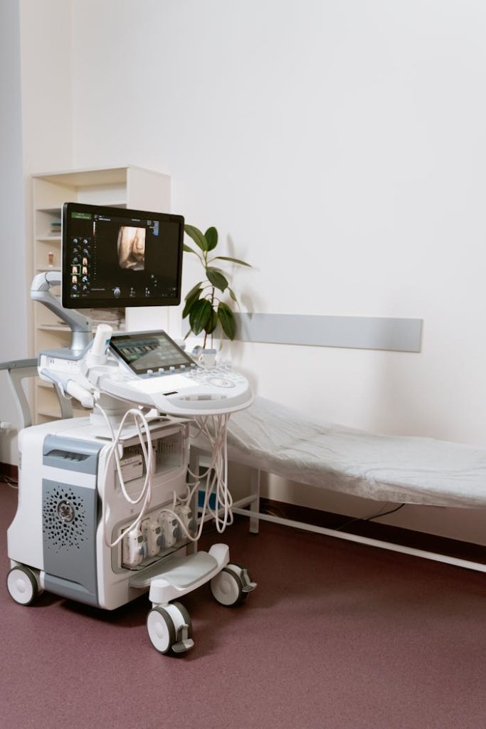 pexels-photo-7089029 Ultrasound machine setup in a clinic room, ready for patient examination.
